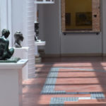 GaleriaTátil da Pinacoteca de São Paulo - imagem panorâmica da galeria com esculturas sobre base branca e piso tátil